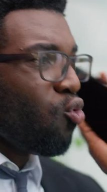 Öfkeli yetkili Afrikalı Amerikalı erkek iş adamı ofiste cep telefonu çakışmalarında bağıran erkek işadamı akıllı telefon görüşmeleri kötü iş iletişimi yanlış anlaşılmalarını bağırarak suçluyor