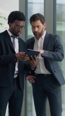 Modern dijital tablet kullanan iki farklı iş adamı, internet üzerinden iş arkadaşlarıyla internet üzerinden iş geliştirme ortakları hakkında konuşuyor.