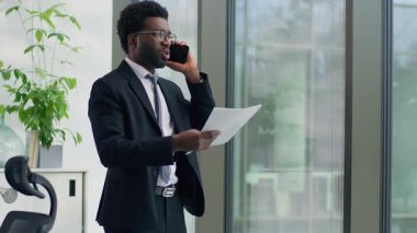 Afrika kökenli Amerikalı iş adamı cep telefonuyla kavga ediyor. Sinirli konuşuyor, akıllı telefondan öfkeli konuşuyor. İş adamı, belgeleri elinde tutuyor ve ofisteki finansal başarısızlığı bağırıyor diye tartışıyor.