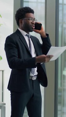 Afrika kökenli Amerikalı iş adamı cep telefonuyla kavga ediyor. Sinirli konuşuyor, akıllı telefondan öfkeli konuşuyor. İş adamı, belgeleri elinde tutuyor ve ofisteki finansal başarısızlığı bağırıyor diye tartışıyor.