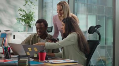 Gayri resmi yaratıcı girişim konuşmasında çok ırklı üç iş arkadaşı dijital tablet laptop yazılım siber uzay Afrikalı Arap iş kadını Kafkasyalı iş kadınlarının verilerini analiz ediyor