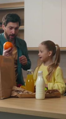 Mutfak evindeki beyaz aile çantalarını boşaltıyor. Doğal ürün alışverişi yapıyorlar. Müşteriler kaliteli ekolojik alışverişin keyfini çıkarıyorlar.