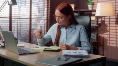 Kafkasyalı iş kadını veri bilgi şemasını analiz ediyor dizüstü bilgisayara benzeyen notlar yazıyor iyi bir işi var gibi görünüyor masa başında evraklarla çalışan mutlu bir iş kadını gülümsüyor.