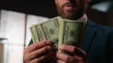 Kesilmiş manzara, dolarları tutan erkek eli, tanınmayacak kadar mutlu, gülümseyen, Kafkasyalı iş adamı, elinde para tutan, ofisteki bütçe birikimlerini sayan,
