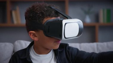 Küçük Afrikalı Amerikalı çocuk, sanal gerçeklikte VR oyunu oynuyor AR teknolojisinde yenilikçi fütüristik oyun siber uzay interneti oynuyor.