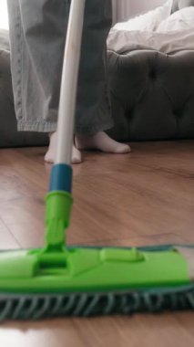 Tanınmayan bir kadın kirli zemini yıkıyor kimliği belirsiz bir kızı temizliyor ev kadını ev sahibi ev hizmetçisi yatak odasında temizlik yapıyor ev temizliği yapıyor ev işlerini paspasla temizliyor ev temizliği yapıyor.