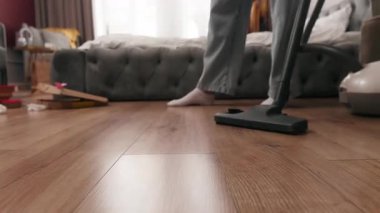 Beyaz bir kadın süpürge temizliyor tozlu yatak odasını elektrik süpürgesi kızıyla temizliyor ev temizlikçisi kadın ev temizliği rutin temizlikçisi partiden sonra yatak odasına ev sahibi kendi kiracısını temizliyor.