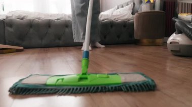 Tanınmayan bir kadın kirli zemini yıkıyor kimliği belirsiz bir kızı temizliyor ev kadını ev sahibi ev hizmetçisi yatak odasında temizlik yapıyor ev temizliği yapıyor ev işlerini paspasla temizliyor ev temizliği yapıyor.