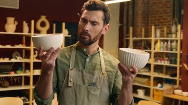 Kafası karışmış Kafkasyalı satıcı, çömlekçi, erkek, erkek, iş adamı, küçük işletme sahibi, iki kase vazo, çanak çömlek, seramik omuz silkme, mağaza atölyesinde omuz silkme.