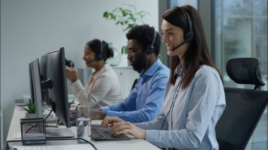 Çağrı merkezi başarısı. Çoklu etnik operatörler bilgisayar yardım hattı hizmet ajansı Kafkasyalı iş kadını yumruğunu sıkma başarılı Hintli Afrikalı iş arkadaşları için ofis kulaklığı çağrı merkezinde çalışıyor.