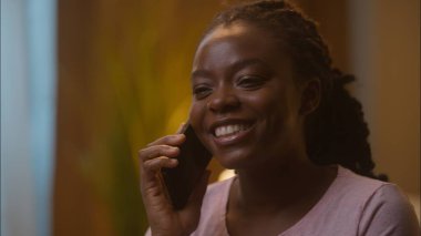 Kapalı fotograf, neşeli, Afro-Amerikalı, etnik kadın bayan müşteri cep telefonuna cevap veriyor. Telefonlara arkadaşça cevap veriyor.