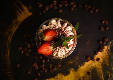 Böğürtlen, nane ve kahve çekirdekleri ile süslenmiş kremalı çilekli tatlı.