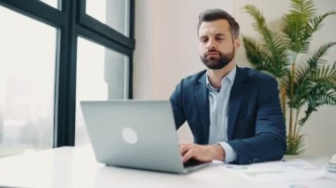 Çok çalışan Kafkasyalı ofis çalışanı, şirket müdürü, yönetici, ofiste bir çalışma masasında oturur, boynuna masaj yapar, sinirini sıkar, uzun süre masada oturur, dinlenmeye, dinlenmeye ihtiyacı vardır.