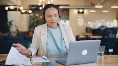 Yoğun odaklı Brezilyalı ya da İspanyol iş kadını, danışman, çağrı merkezi çalışanı, kulaklıkla ofiste çalışma masasında oturuyor, müşteriye uzaktan danışmanlık yapıyor, tavsiyeler veriyor, soruları cevaplıyor.