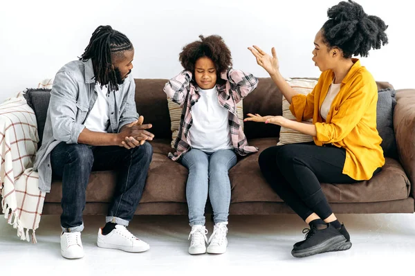 Difficulties in the relationship of parents with the child, conflict. African American parents sort things out with their preschool daughter, yell at her, the child covered her ears, ignores. Abuse