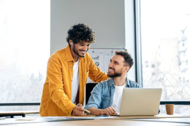 Modern ofisteki projelerde birlikte çalışan iki başarılı yaratıcı erkek işçi, yeni ilginç fikirleri, son teslim tarihlerini ve tanıtım stratejisini tartışıyor.