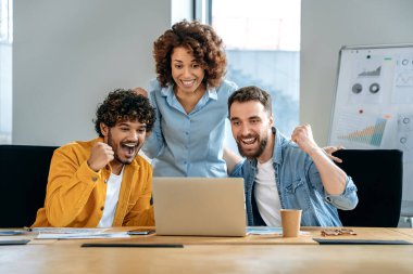 Yaratıcı ofisteki duygusal jestler yapan bir şirketin heyecanlı çok ırklı çalışanları, başarıya sevinen, iyi satış sonuçlarını kutlayan, finansal hedefe ulaşan, iyi anlaşma, sözleşme