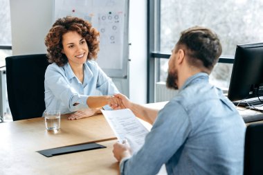 İşbirliği konsepti. Kadın ve erkek, iş adamları, projede başarılı bir şekilde işbirliği yaptılar, bir anlaşma imzaladılar, bir sözleşme imzaladılar, el sıkıştılar. Yeni bir işe alınan Afrikalı Amerikalı kadın.