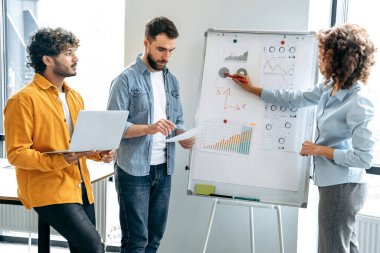 Hedefler ve strateji. Çok ırklı iş adamları beyin fırtınası yapıyor, mali tabloların yanında duruyor, geliri tahmin ediyor, riskleri analiz ediyor, hedefler belirliyor. İşbirliği konsepti, takım çalışması