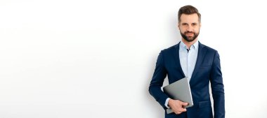 Takım elbiseli başarılı beyaz iş adamının panoramik fotoğrafı, seo, yönetici, broker, finansal danışman, izole edilmiş beyaz arka planda dur, dizüstü bilgisayarı tut, kameraya bak, gülümse.