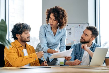 Farklı uluslardan başarılı insanlar, yaratıcı iş adamları, modern bir ofiste bir proje üzerinde birlikte çalışıyorlar, sunumu izliyorlar, fikirleri tartışıyorlar, beyin fırtınası yapıyorlar. Takım çalışması, işbirliği
