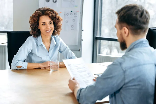 stock image Two people sitting at a desk in office, have successful negotiations for job interview, agreed on cooperation, signed contract, smile. African American woman is hired on a new job. Deal, agreement