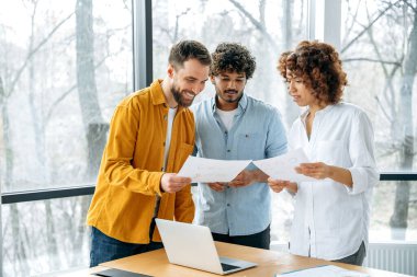 Yaratıcı iş ekibi. Pozitif çok ırklı ortaklar ofiste toplandı, kendine güvenen iş adamları yeni projeleri, yaratıcı fikirleri, tanıtım stratejilerini, finansal riskleri ve kârları analiz etmeyi, gülümsemeyi tartıştılar.