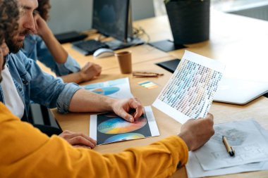 Tasarım projesi konsepti. Pantone renk paleti ve yaratıcı tasarımcıların omuzlarının üstünden evin düzeni, renkleri seçiyorlar, bir düzen geliştirmeye çalışıyorlar, fikirleri tartışıyorlar.
