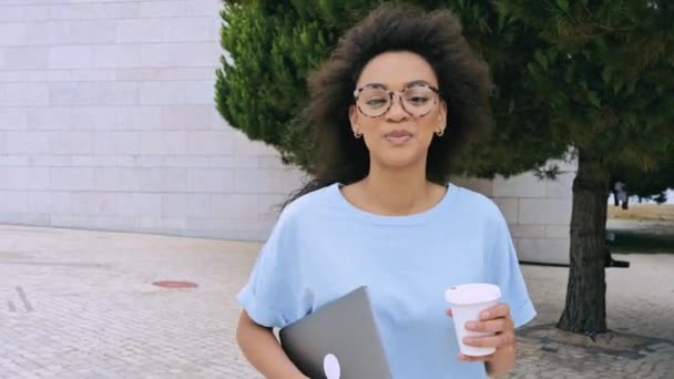 긍정적 스러운 아프리카 미국인젊은 곱슬머리 프리랜서 안경을 셔츠를 노트북을 야외를 — 비디오
