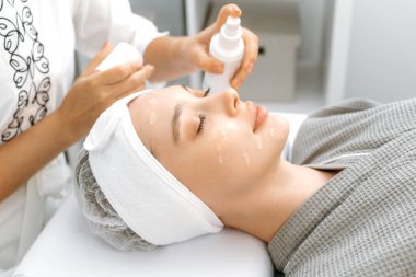 Beyaz tenli güzel bir kadının yüzüne cilt bakımı işlemleri, beslenme ve nemlendirmeden önce temizlik için jel sürmek. Güzellik konsepti. Deri bakım prosedürleri