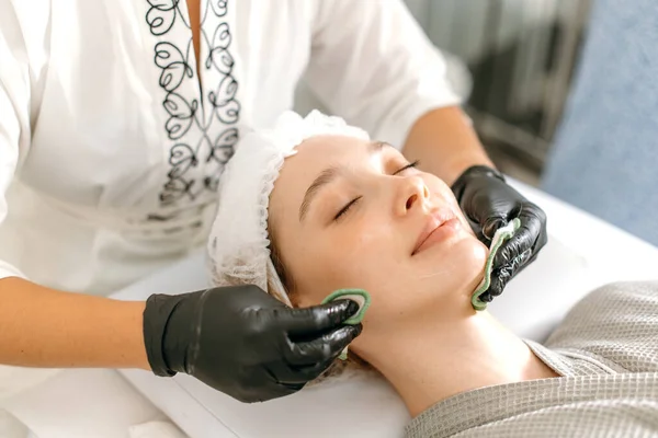 Kosmetolog Dalam Sarung Tangan Medis Hitam Membersihkan Wajah Seorang Wanita — Stok Foto