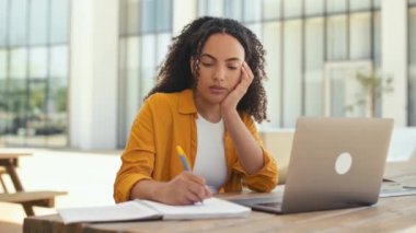 Sleep at work or study. Tired curly haired brazilian or latino girl, sits outdoors with laptop, fell asleep while studying or working online, feeling tired and lack of sleep, napping with closed eyes