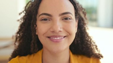 Kız öğrenci ya da serbest çalışan. Güzel İspanyol ya da Brezilyalı kıvırcık saçlı kadının yakın plan video portresi. Çekici, sevimli, dişlek gülüşlü kameraya bakıyor. Açık havada giyinmiş gibi poz veriyor.