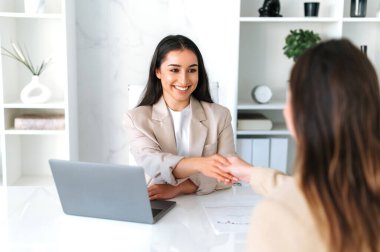 Ortaklık kavramı, anlaşma, anlaşma. Mutlu Arap ya da Hintli iş kadını, finans müdürü, yönetici ofiste iş arkadaşıyla fikir ve planlama stratejisini tartışıyor, beşlik çakışıyor, gülümsüyor.