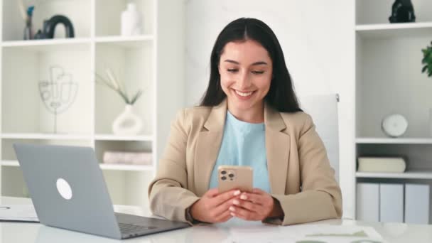 긍정적 아라비아 우아한 사무실에서 직장에 그녀의 스마트 고객과 메시징 화면을보고 로열티 프리 스톡 푸티지