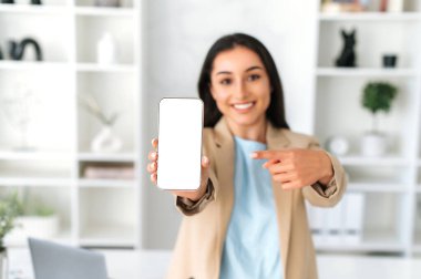 Beyaz ekranlı Gadget. Ofis telefonunda reklamınız ya da sunumunuz için boş beyaz maket ekran ile kameraya gülümseyen güzel Hintli ya da Arap kadın.