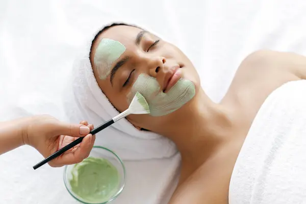 Close Procedimento Beleza Terapeuta Aplicando Máscara Verde Metade Rosto Uma Imagens Royalty-Free