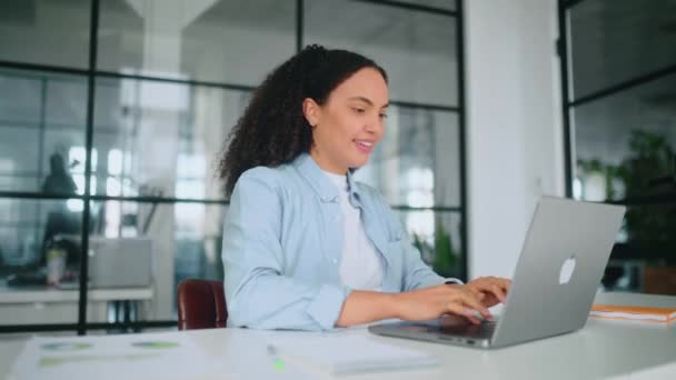 在工作日休息 快乐的巴西女人或惊慌失措的女人 公司的员工 在工作场所休息 在办公室的笔记本电脑上完成工作 她把手放在脑后 闭上眼睛 面带微笑 图库视频