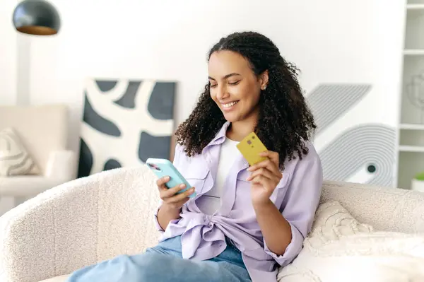 Gelukkige Mooie Braziliaanse Spaanse Krullende Vrouw Met Smartphone Creditcard Voor Rechtenvrije Stockfoto's