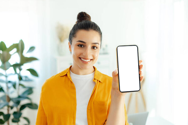 Positive Pretty Arabian Indian Young Woman Orange Shirt Holding Smartphone Stock Picture