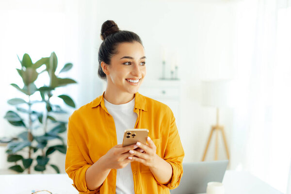 Smiling Pretty Arabian Indian Young Woman Orange Shirt Using Smartphone Stock Image