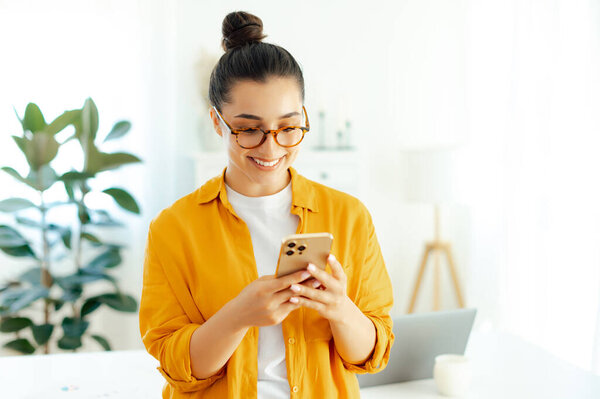Smiling Arabian Indian Young Woman Orange Shirt Using Mobile Phone Stock Image