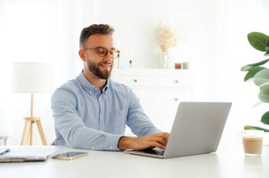 Kendine güvenen genç iş adamı, şirket müdürü ya da mavi gözlüklü CEO 'su. Yeni bir proje üzerinde çalışıyor. Parlak ve modern bir ofis alanında.