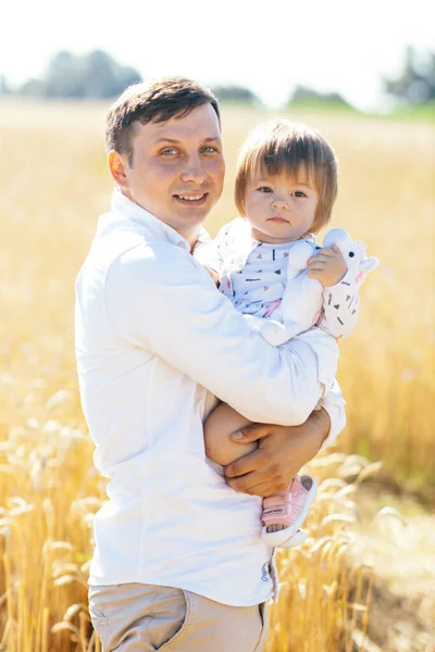 stock image young man with beautiful daughter walking in wheat field. father tenderly touches hir sons hair, holding hands, hugs. High quality photo