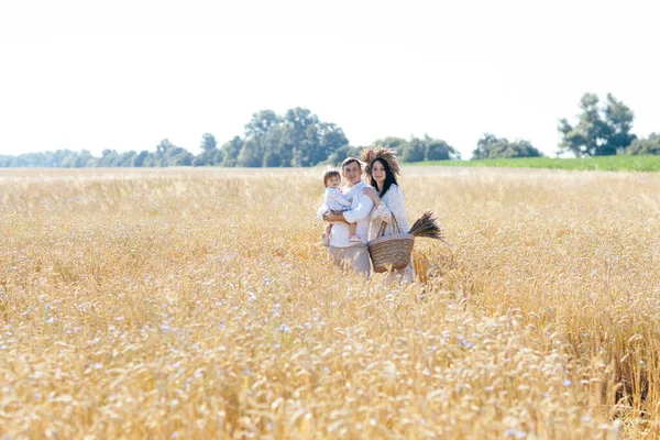 Mutlu bir çocukluk, aile buğday tarlasında yürüyor. Anne, baba ve küçük kız birlikte dışarıda vakit geçiriyorlar. Ebeveynler ve çocuklar yaz otlaklarında oynuyorlar. Yüksek kalite fotoğraf