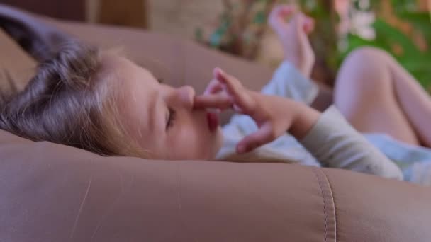 Menina Deita Numa Cadeira Saco Escolhe Nariz Imagens Alta Qualidade — Vídeo de Stock