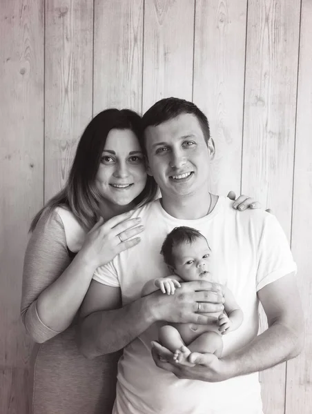 stock image black and white photo. of a young happy family, man holding his newborn daughter in his arms. High quality photo