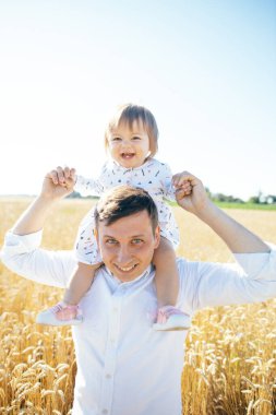 Güzel kızı olan genç bir adam buğday tarlasında yürüyor. Baba şefkatle oğullarının saçlarına dokunur, el ele tutuşur, sarılır. Yüksek kalite fotoğraf