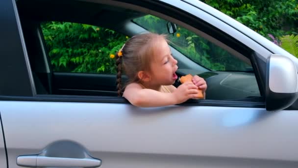 Urocza Dziewczynka Siedząca Samochodzie Wyglądająca Przez Okno Naturę Jedząca Coocke — Wideo stockowe