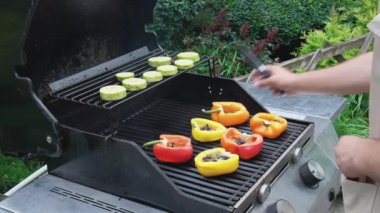 A man cooks a pepper on the grill. Juicy fresh peppers with egg, cherry tomatoes and cheese are grilled. Cooking delicious vegetarian dishes in the home kitchen. High quality FullHD footage